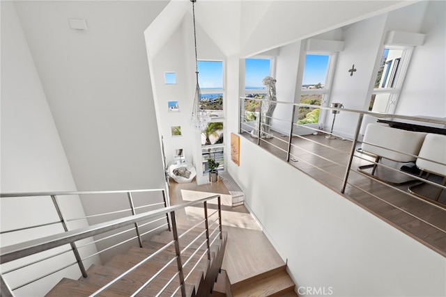 stairway featuring vaulted ceiling and hardwood / wood-style flooring