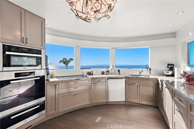 766 Pelican, Laguna Beach, CA 92651 - kitchen featuring dishwasher, a warming drawer, stainless steel double oven, light wood finished floors, and a sink