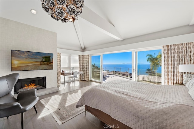 bedroom with hardwood / wood-style floors, access to outside, a fireplace, vaulted ceiling with beams, and a water view