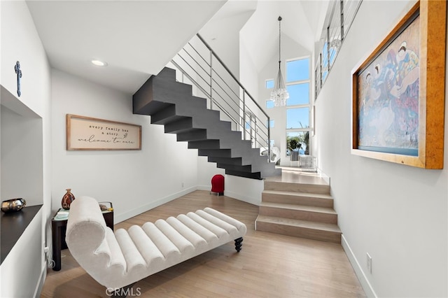 stairs with an inviting chandelier and hardwood / wood-style flooring