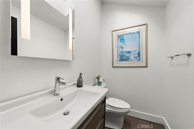 bathroom featuring hardwood / wood-style flooring, toilet, and vanity