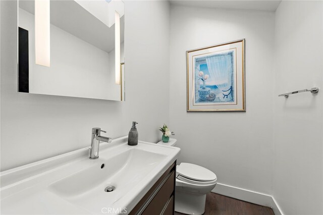 766 Pelican, Laguna Beach, CA 92651 - bathroom with wood finished floors, toilet, vanity, and baseboards