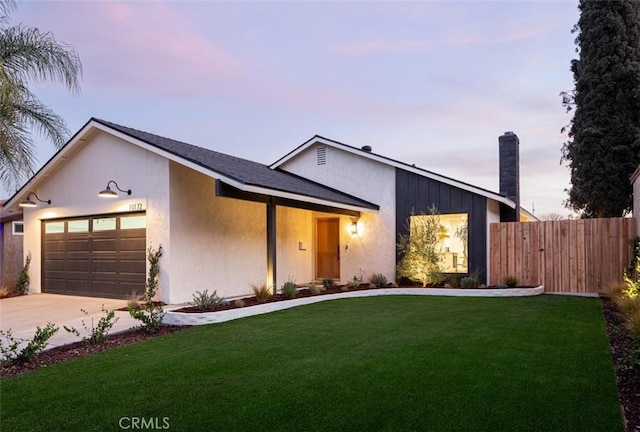 view of front of home with a garage and a yard