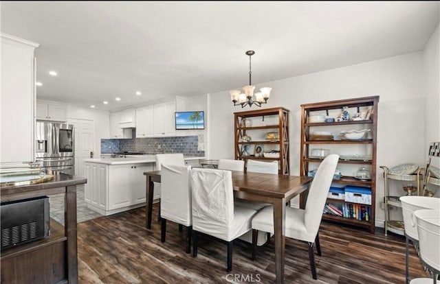 dining area with dark hardwood / wood-style floors and a chandelier