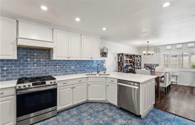 kitchen featuring appliances with stainless steel finishes, sink, hanging light fixtures, and white cabinets