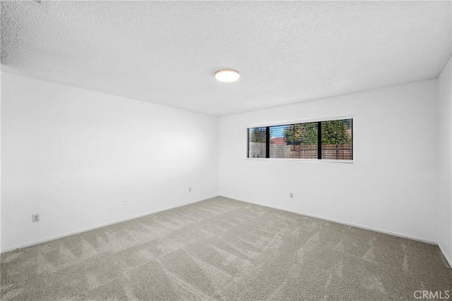 unfurnished room featuring carpet and a textured ceiling