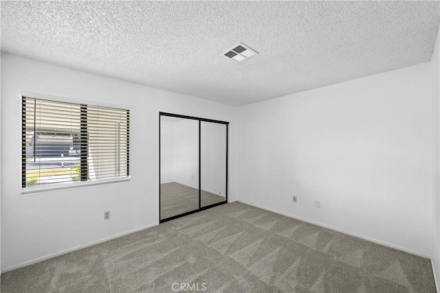 unfurnished bedroom featuring light colored carpet and a textured ceiling