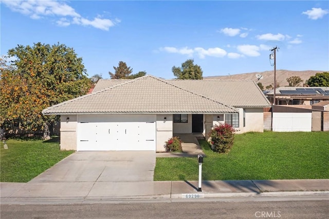 ranch-style home featuring a front lawn and a garage