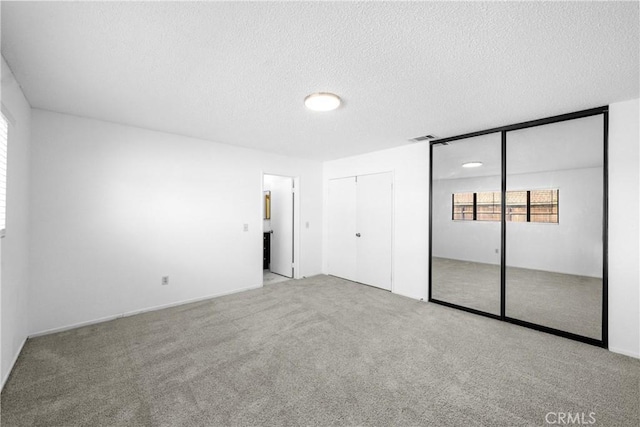 unfurnished bedroom with light carpet and a textured ceiling