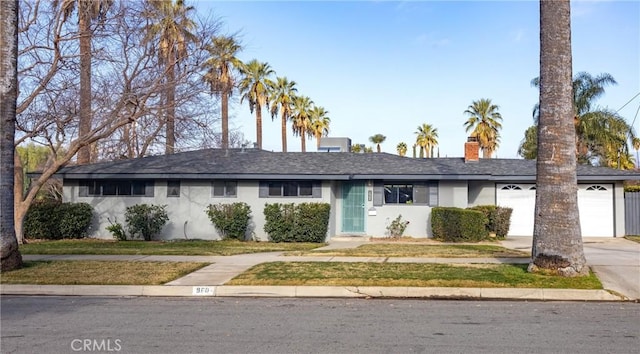 ranch-style home with a garage and a front yard