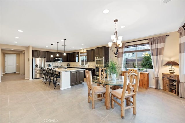 tiled dining space featuring a notable chandelier