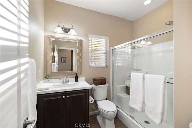 bathroom with tile patterned flooring, vanity, an enclosed shower, and toilet