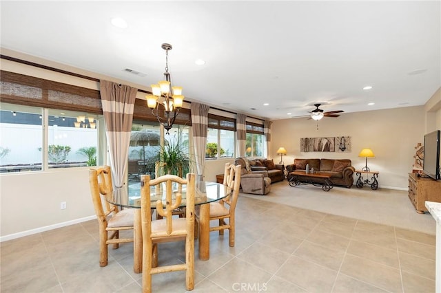 dining space with light tile patterned floors, ceiling fan with notable chandelier, and a healthy amount of sunlight