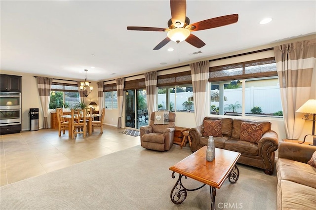 tiled living room featuring ceiling fan with notable chandelier