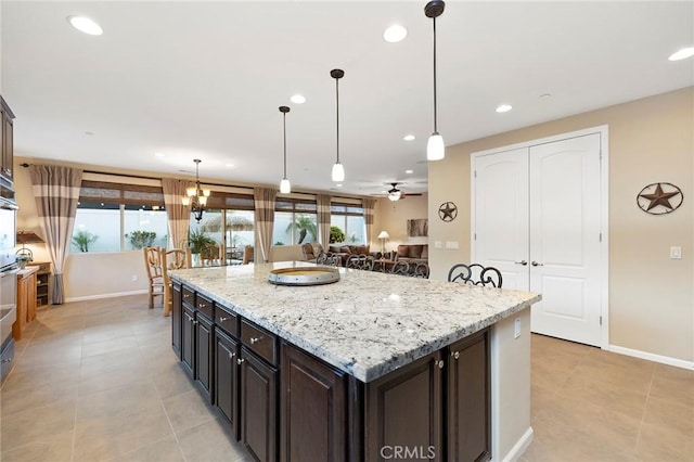 kitchen with plenty of natural light, a center island, pendant lighting, and dark brown cabinetry