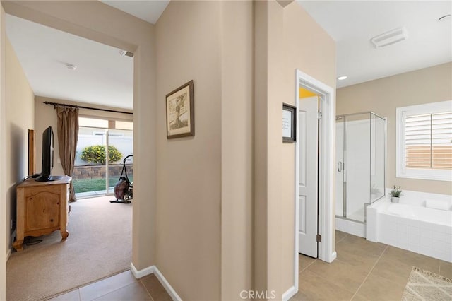 hallway featuring light colored carpet