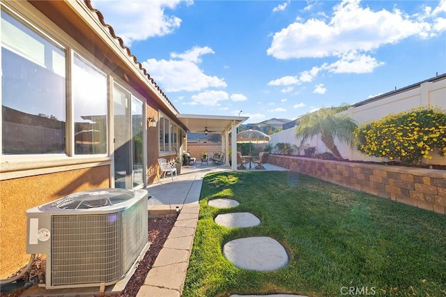 view of yard featuring ceiling fan, a patio, and central air condition unit