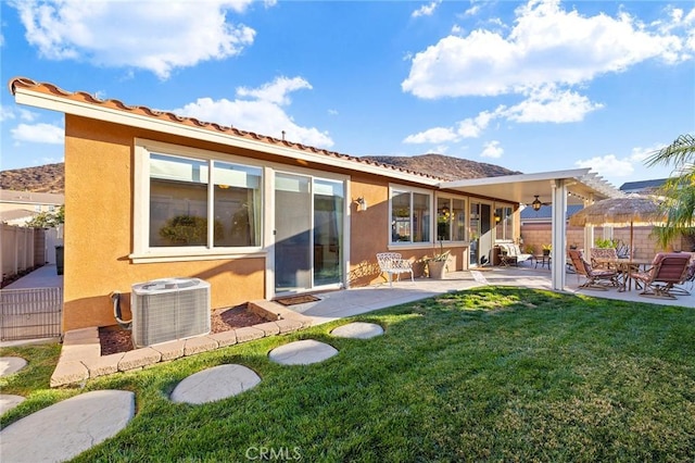 rear view of property with cooling unit, a yard, a pergola, and a patio