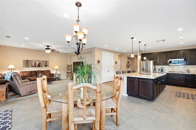 tiled dining area with ceiling fan with notable chandelier