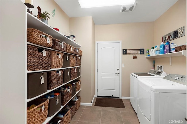 washroom with light tile patterned floors, a skylight, and washing machine and dryer