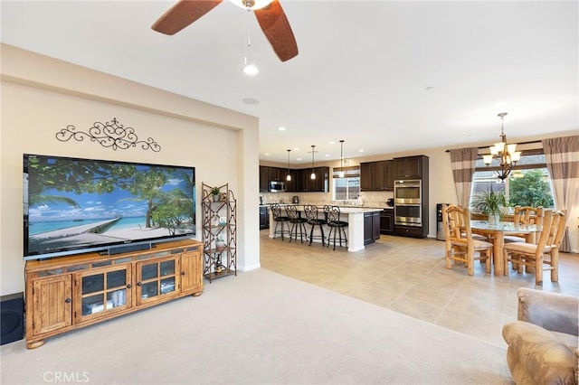 living room featuring ceiling fan with notable chandelier and light tile patterned flooring