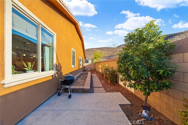 view of side of home with a mountain view and a patio