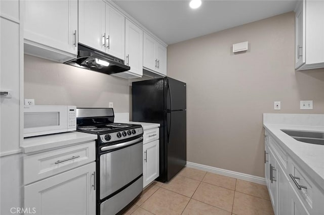 kitchen featuring light tile patterned floors, white cabinetry, stainless steel gas range oven, black fridge, and sink