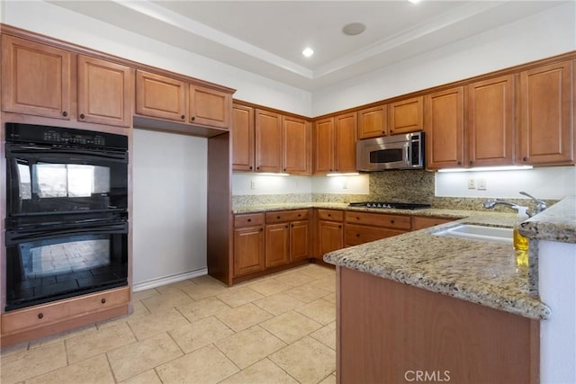 kitchen with black appliances, a raised ceiling, sink, light tile patterned floors, and light stone counters