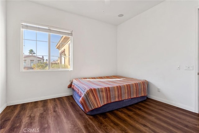 bedroom with dark wood-type flooring