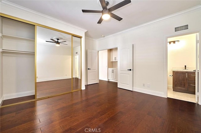 unfurnished bedroom with ensuite bathroom, hardwood / wood-style floors, ceiling fan, a closet, and crown molding