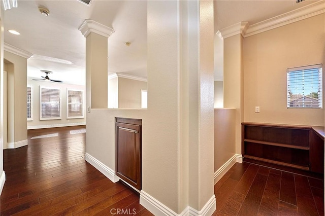 hallway with decorative columns, dark hardwood / wood-style flooring, and crown molding