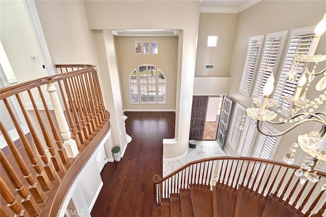 foyer entrance with dark wood-type flooring and ornamental molding