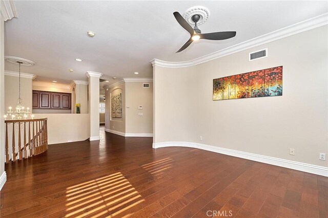 unfurnished living room with dark wood-type flooring, ceiling fan with notable chandelier, and ornamental molding