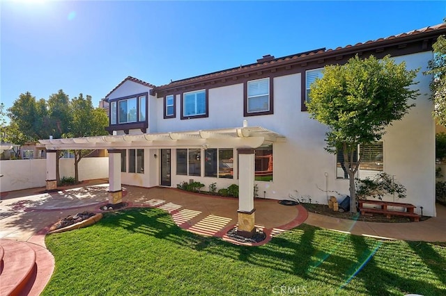 rear view of house featuring a lawn, a pergola, and a patio