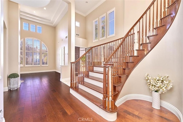 entrance foyer featuring a high ceiling, crown molding, and hardwood / wood-style flooring