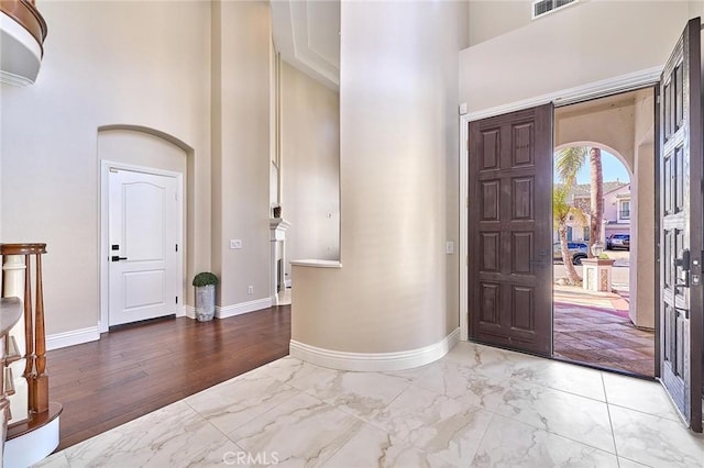 foyer entrance featuring light hardwood / wood-style floors and a towering ceiling