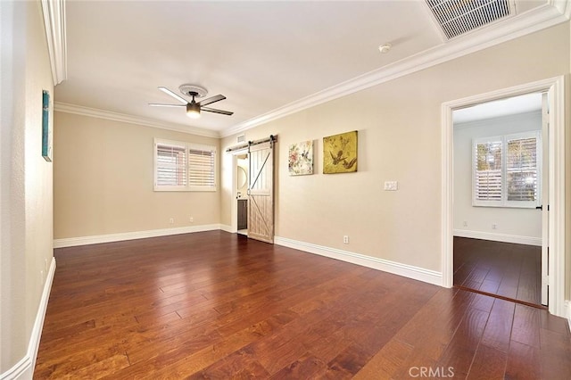 empty room featuring ceiling fan, ornamental molding, a barn door, and dark hardwood / wood-style floors