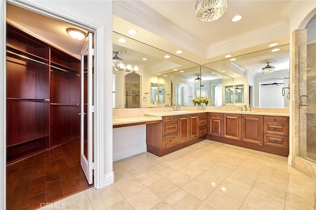 bathroom with tile patterned floors, a shower with door, vanity, a notable chandelier, and crown molding