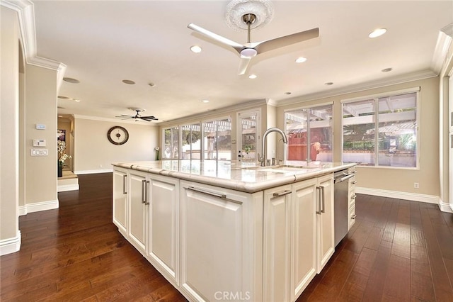 kitchen featuring ceiling fan, a wealth of natural light, sink, and a center island with sink