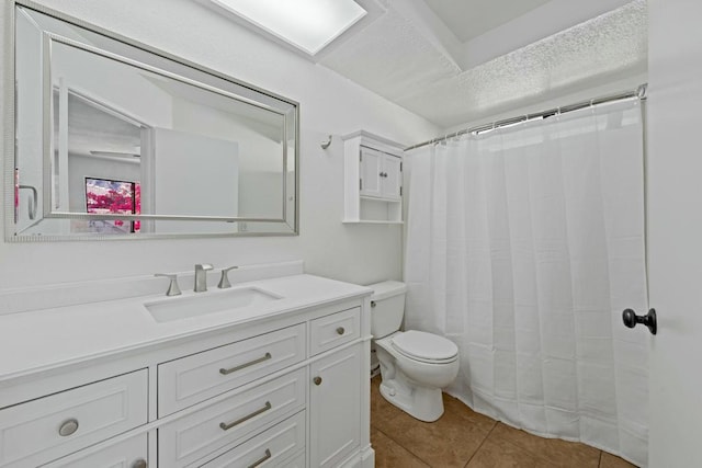 bathroom featuring a textured ceiling, tile patterned floors, vanity, toilet, and walk in shower