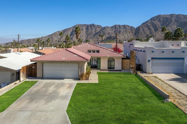 view of front facade featuring a front lawn, a mountain view, and a garage