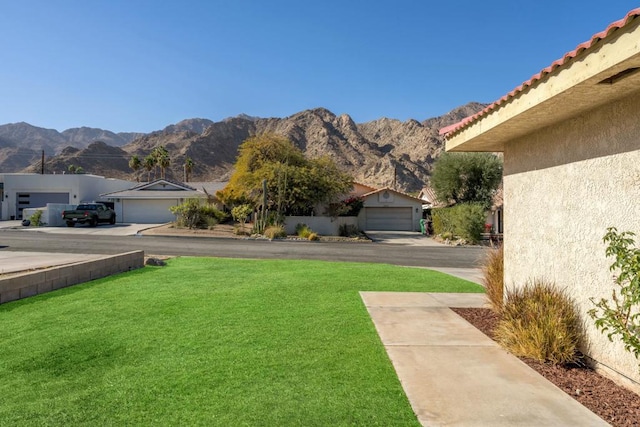 view of yard with a mountain view and a garage