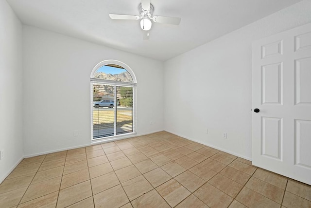 tiled spare room with ceiling fan