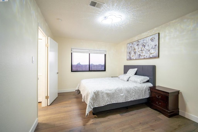 bedroom featuring hardwood / wood-style floors and a textured ceiling