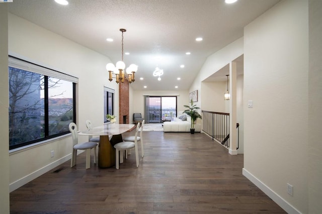 dining area featuring lofted ceiling, dark hardwood / wood-style floors, and an inviting chandelier