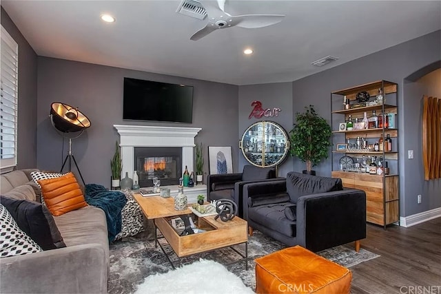 living room featuring ceiling fan and dark hardwood / wood-style floors