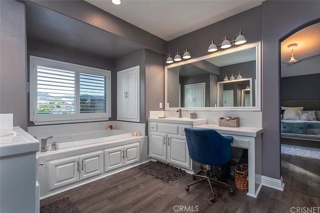 bathroom featuring a tub to relax in, wood-type flooring, and vanity