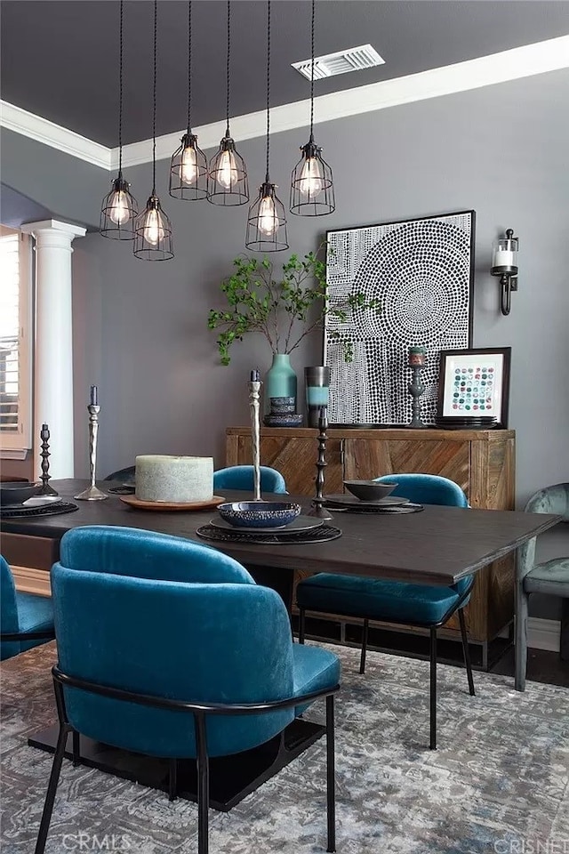 dining room with crown molding, a raised ceiling, and decorative columns