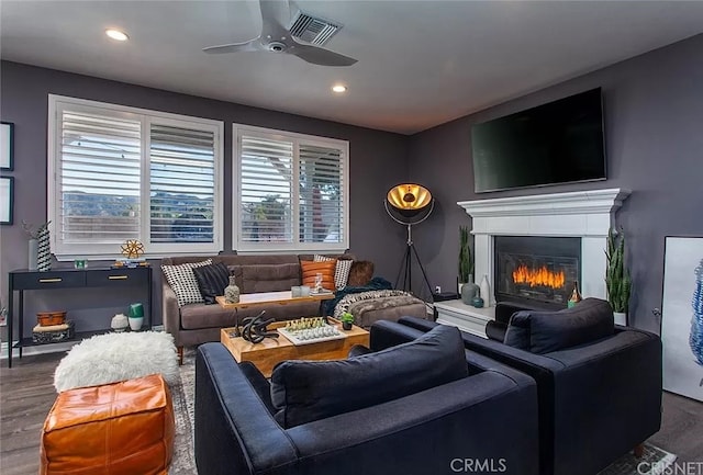 living room featuring ceiling fan and dark hardwood / wood-style flooring