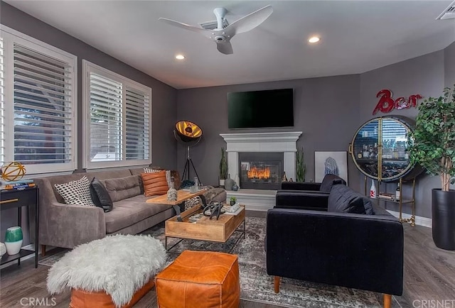 living room with ceiling fan and dark wood-type flooring